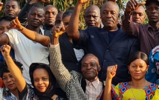 A group of people celebrating with their fists in the air.
