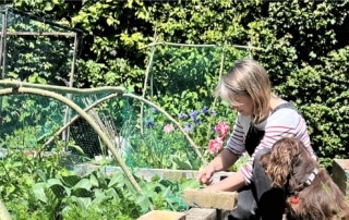 Julie Thomas in the garden with her cocker spaniel looking on
